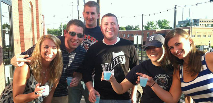 Five friends outside on the patio holding bright blue pudding shots.